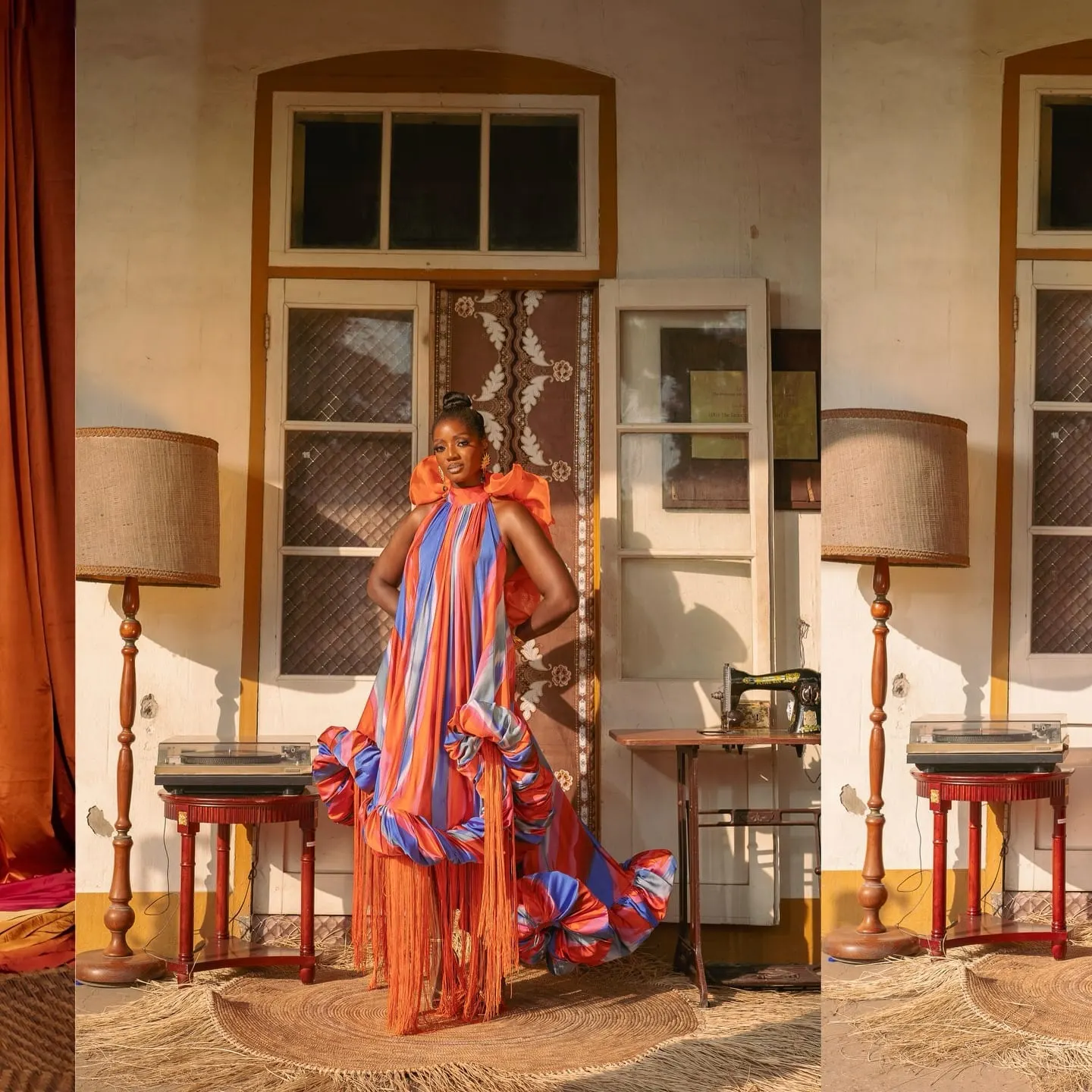Model in a fringed orange-and-blue gown stands on a woven mat between a floor lamp and vintage sewing machine.