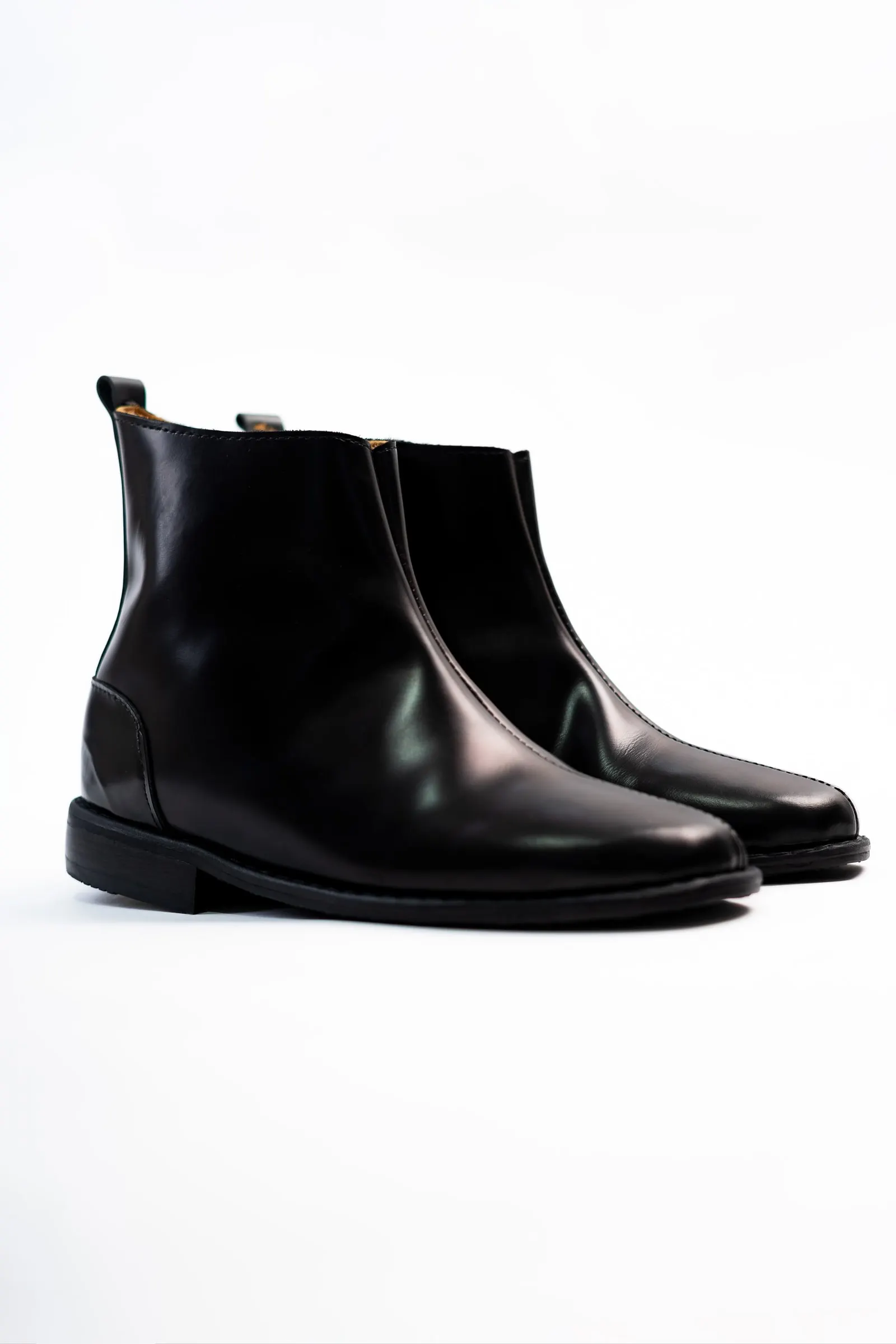 A pair of black leather zip-sided ankle boots on a white background.