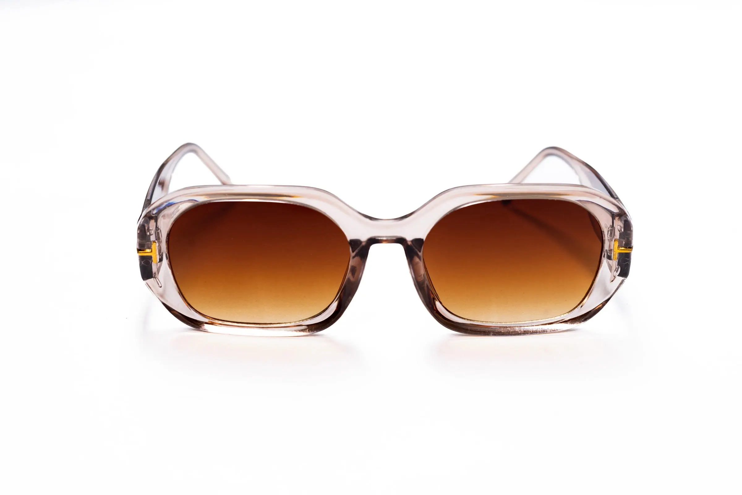 A pair of sunglasses with clear frames and brown gradient lenses on a white background.